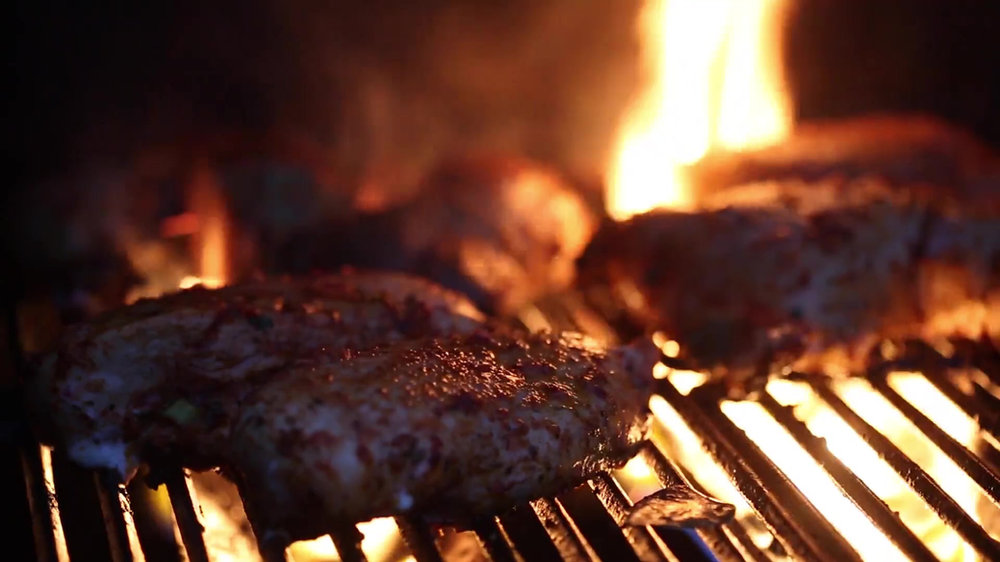 Carne cocinándose sobre la parrilla encendida